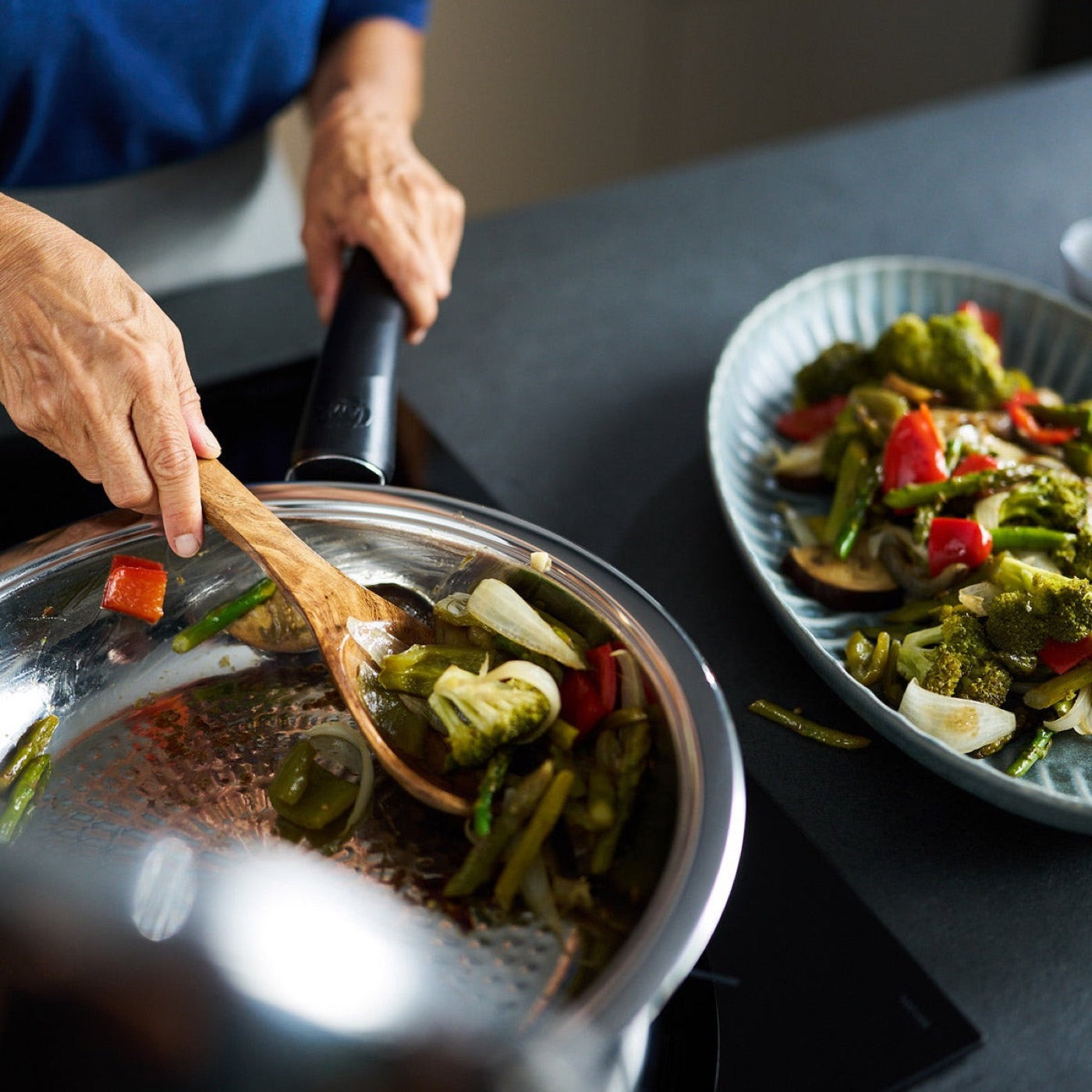 Vegetables being served from an uncoated AMC stainless steel pan